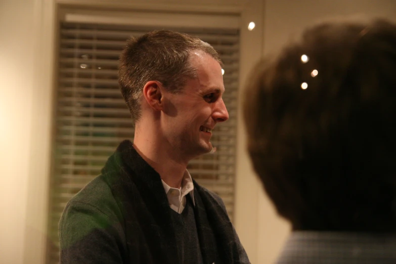 a man in a room looking at a woman