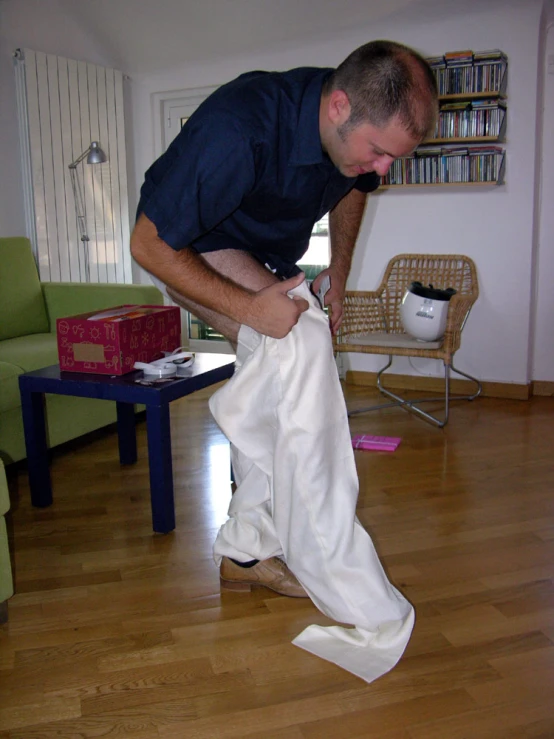 a man in blue shirt and white pants