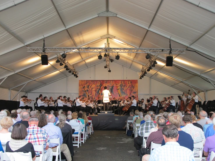 a band performing inside a tent with people watching