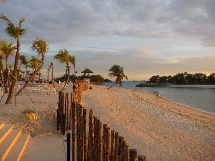 a sandy beach at sunset on an ocean