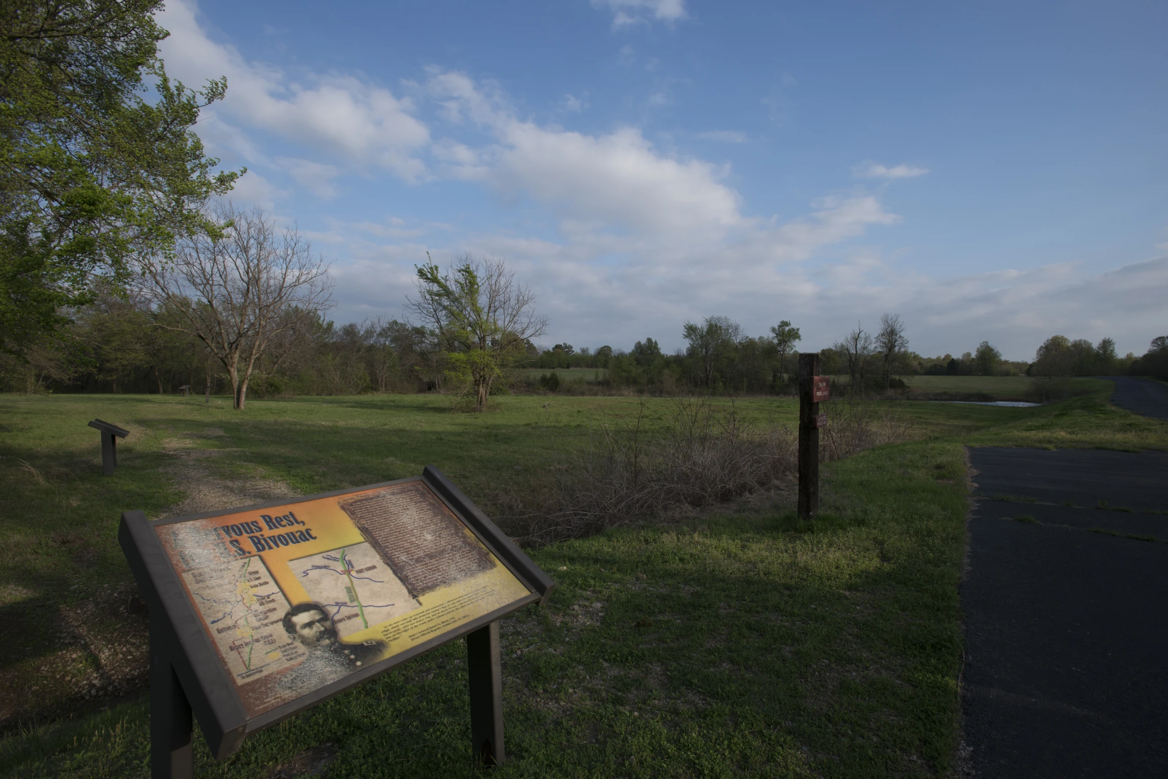 an information sign sitting next to a trail in the woods