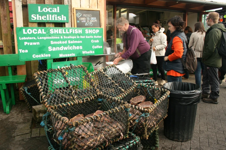 a man is at a stand selling sea shells