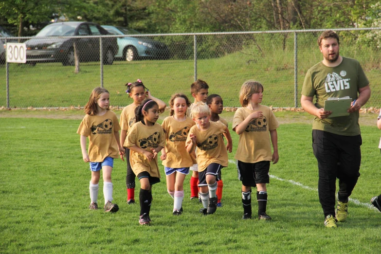 some little girls in soccer uniforms on a field