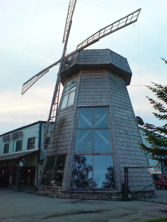 a windmill style structure stands in front of some buildings