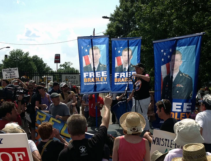 a crowd of people with patriotic signs in front of them