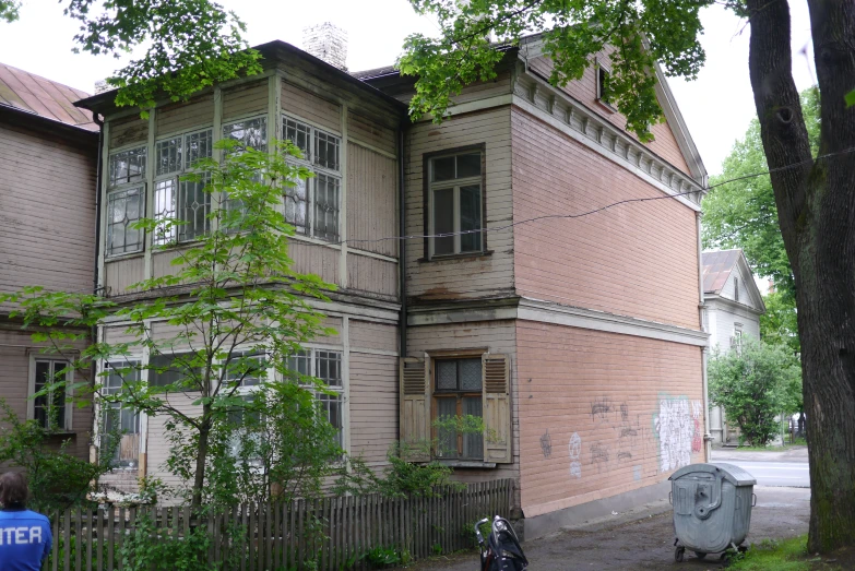 old wooden house with a metal fence in front