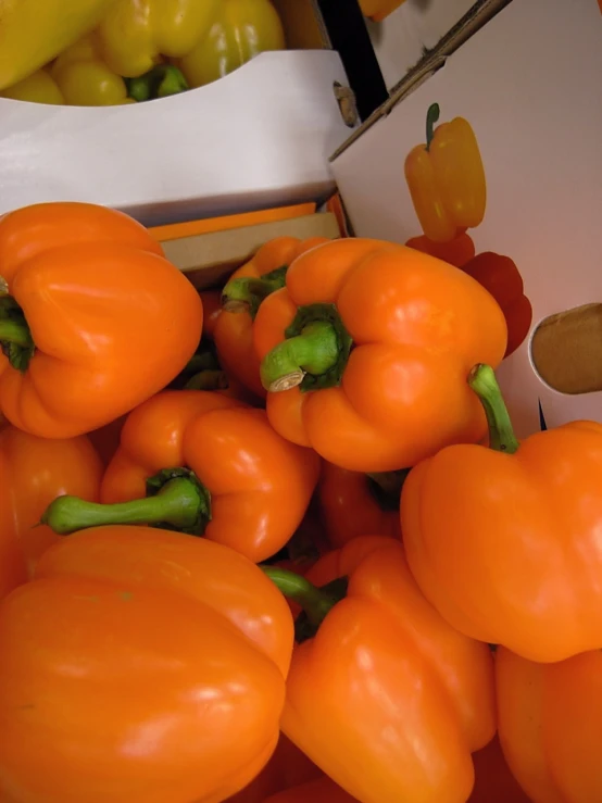 a group of orange peppers sitting on a white box