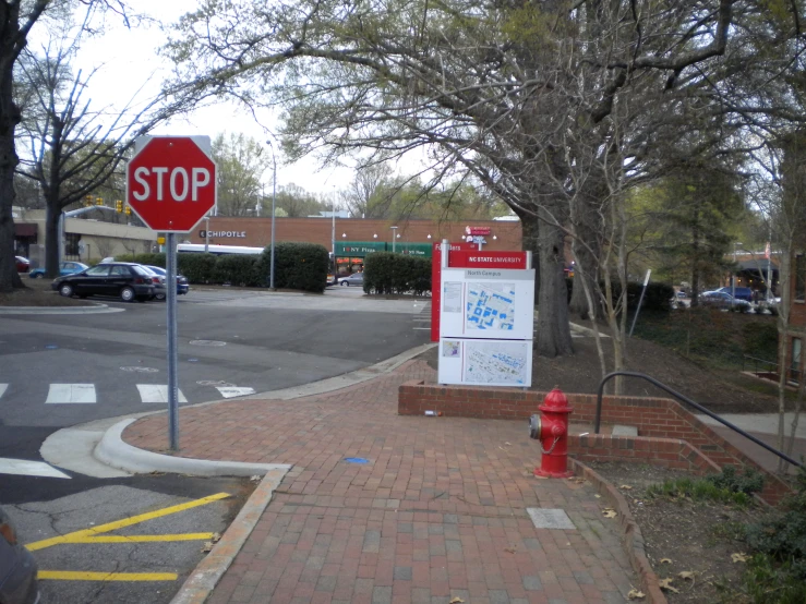 a red fire hydrant sitting next to a sign on a sidewalk