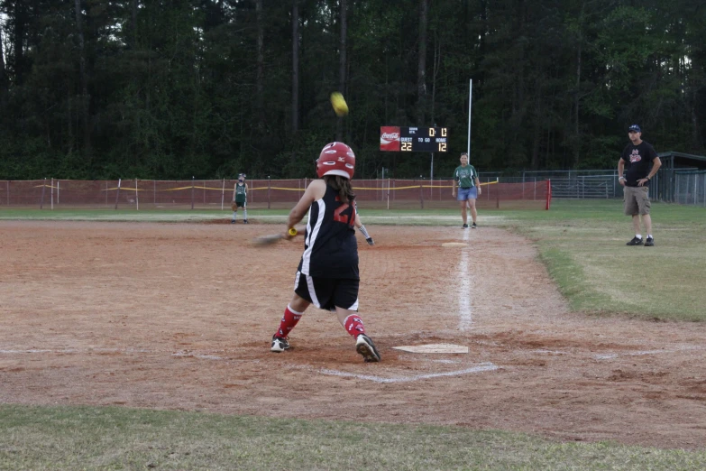  hitting a softball with her bat