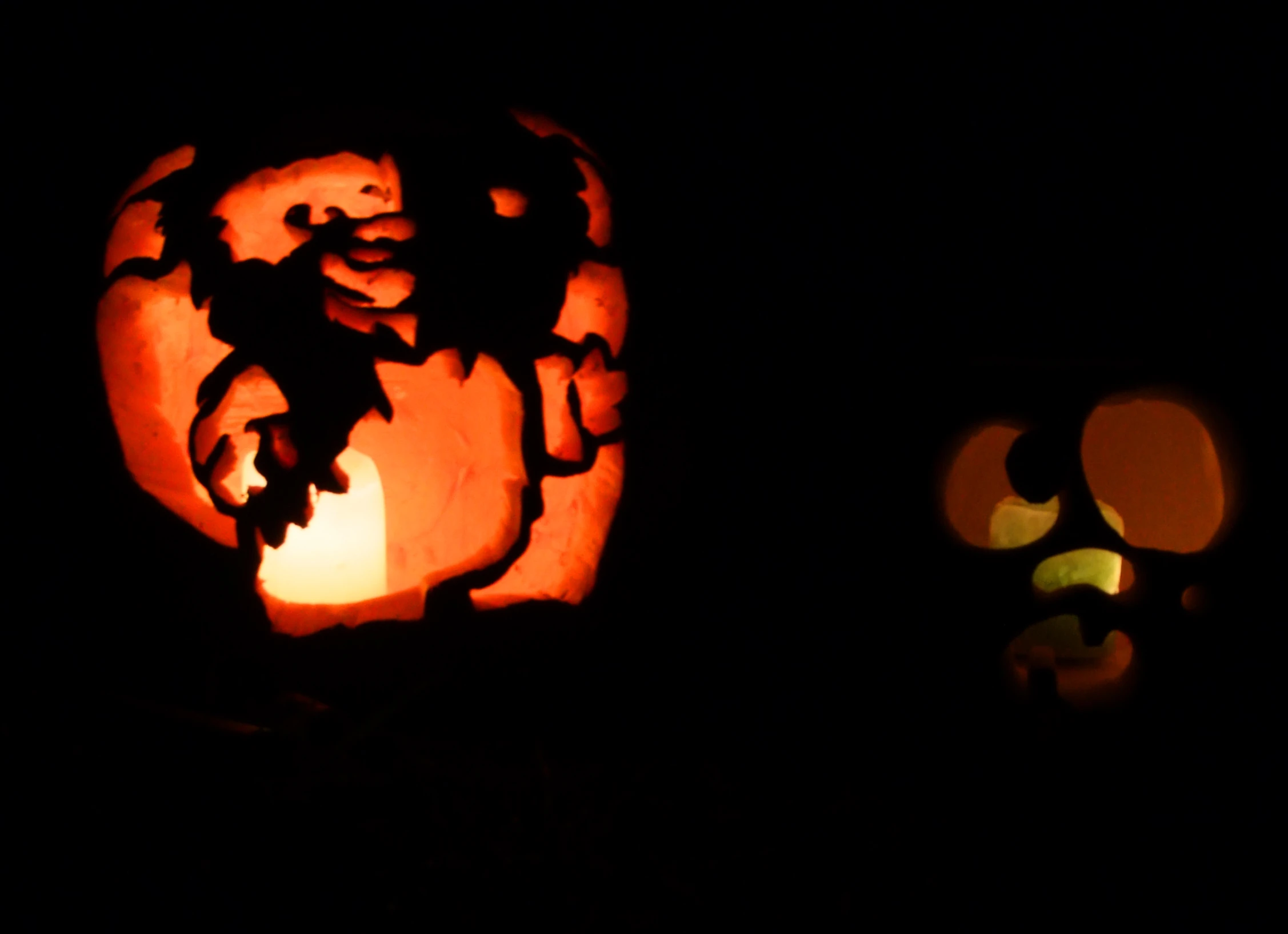 a lit up halloween pumpkin on a black background