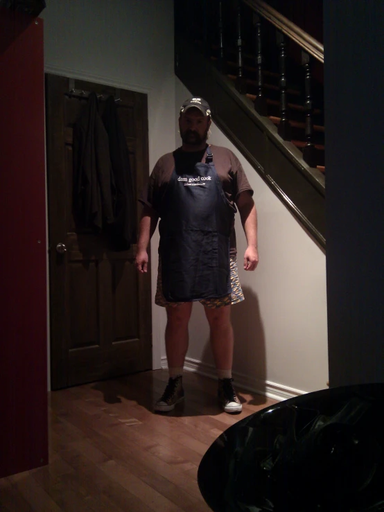 the man wearing an apron and hat is standing in a doorway