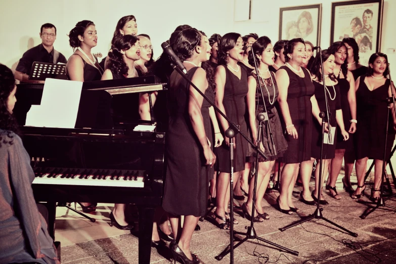 a woman in a dress sings at a piano while singing for choirs