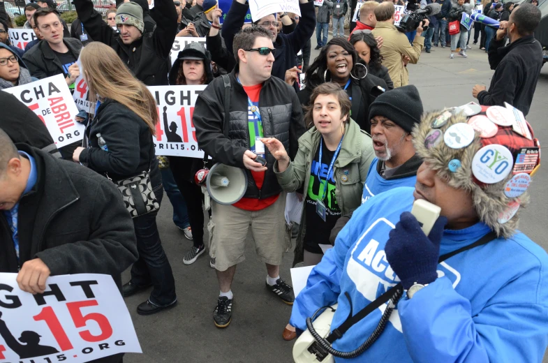 a crowd is protesting with signs and hats