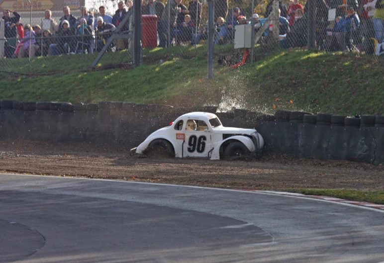 an antique race car is making it's way down the dirt track