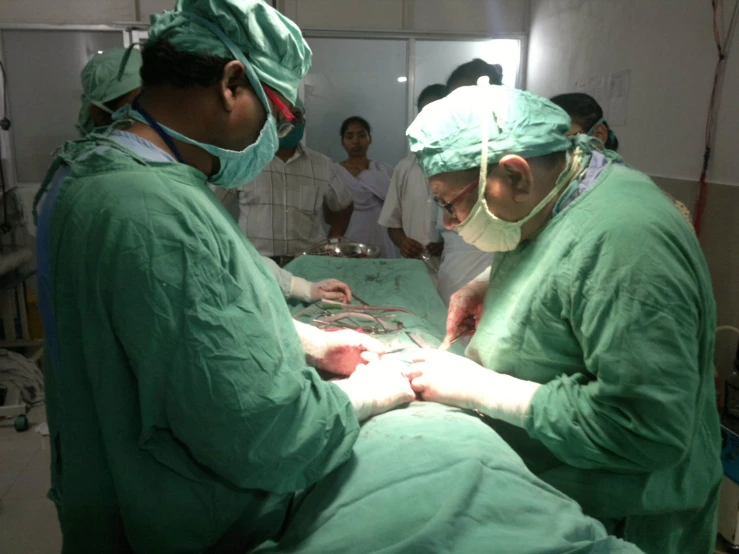 doctors performing  on the belly of a patient