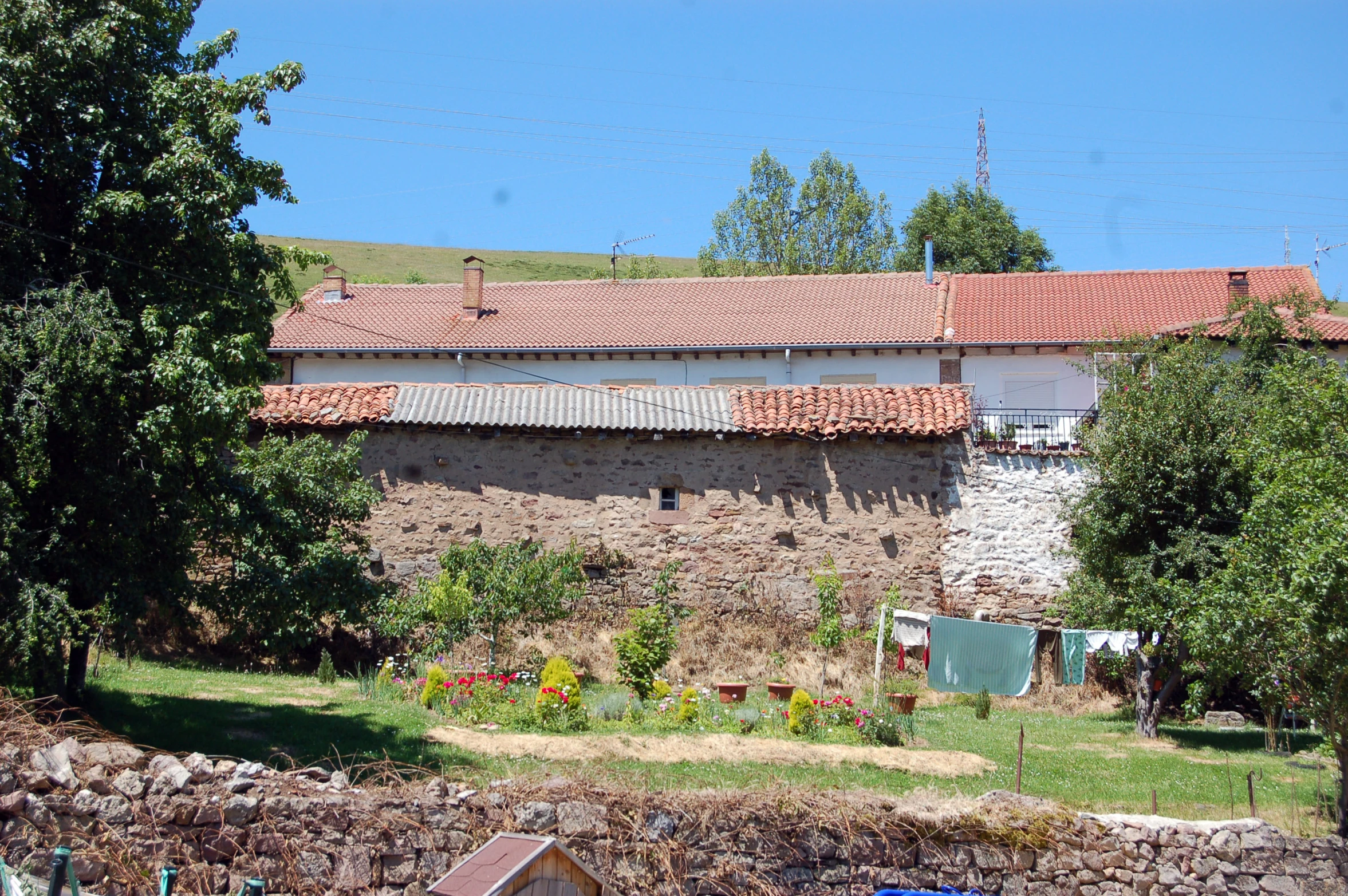 a house is sitting by a very large rock wall