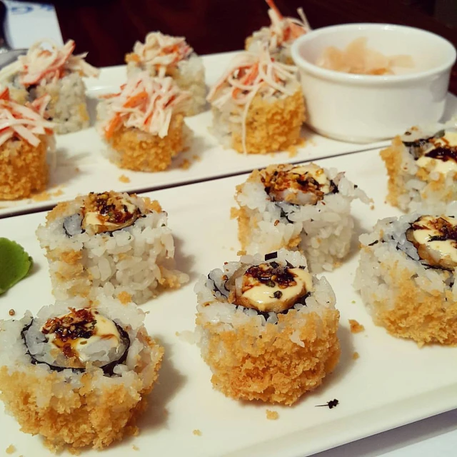 an assortment of various types of sushi on a long platter