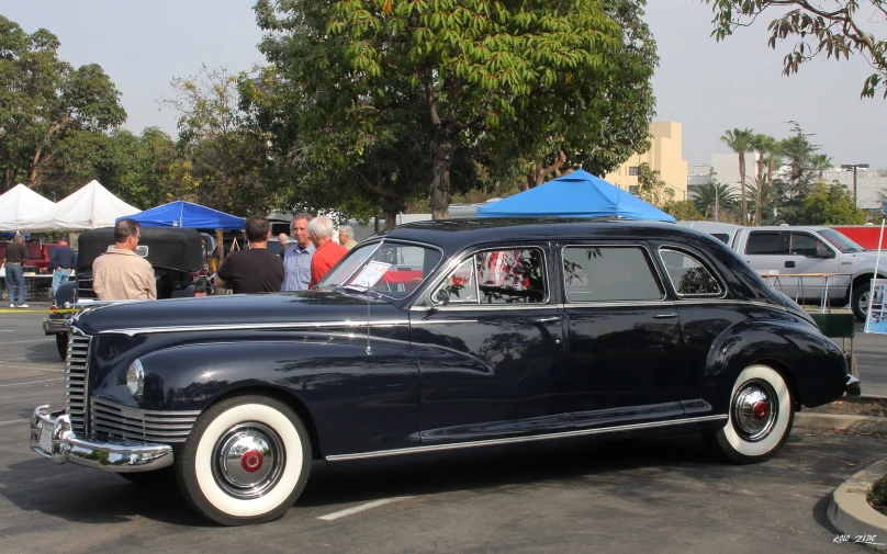 a vintage black car with two blue covers on the side