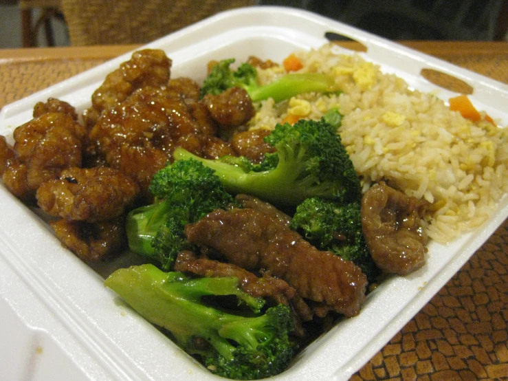 broccoli, meat and rice in a styrofoam container on a table