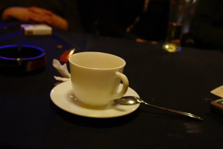 there is a coffee cup on the table with silverware