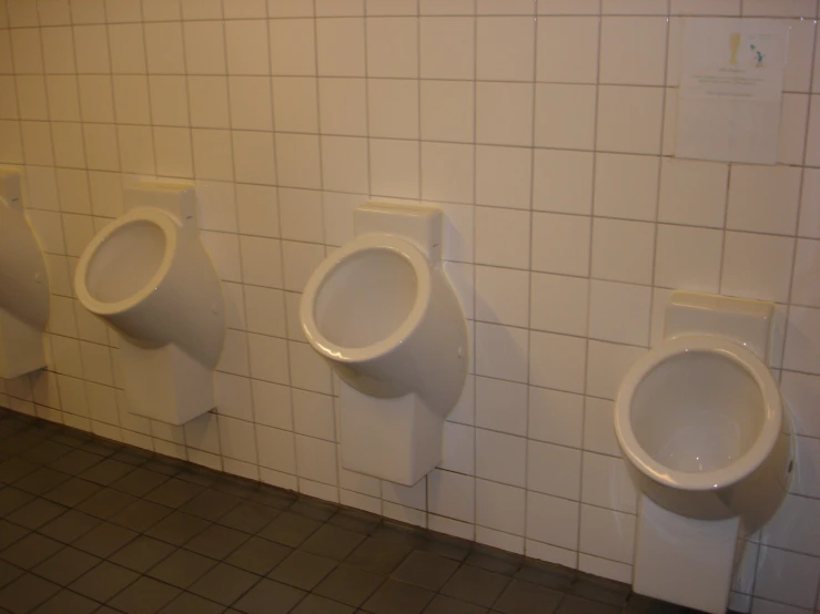 three urinals are lined up in a public bathroom