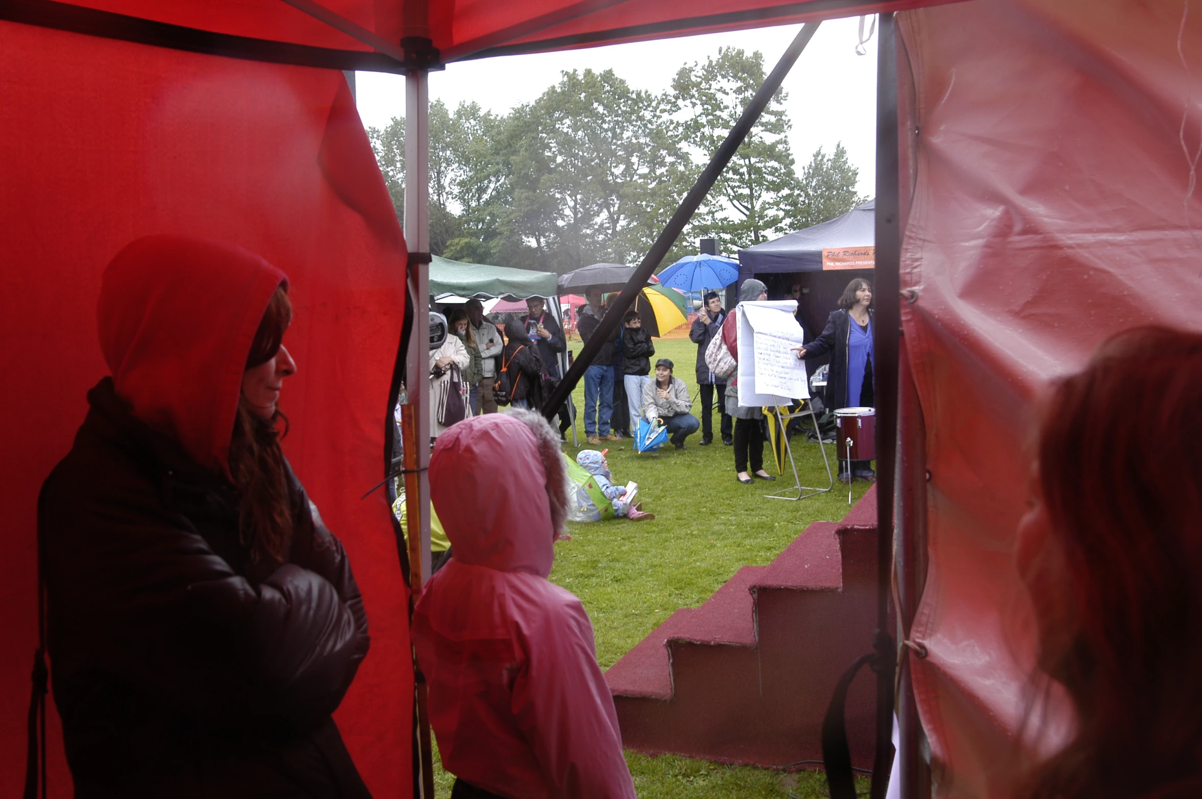 a group of people standing next to each other under an umbrella