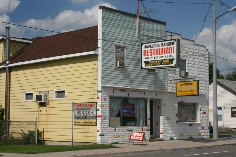 a blue building with yellow walls and red and white signs