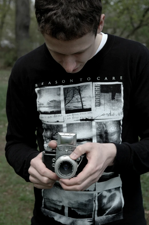 a boy holding his camera in one hand and his other hands over the camera