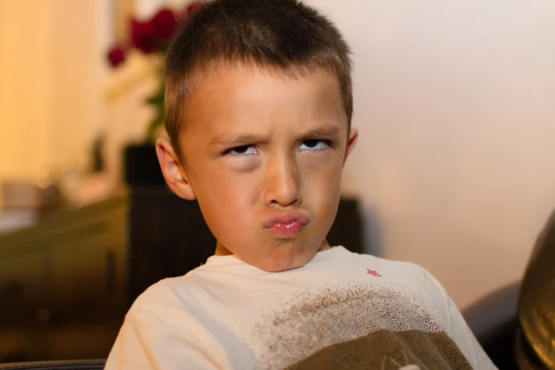 a boy is standing in the room and making a face