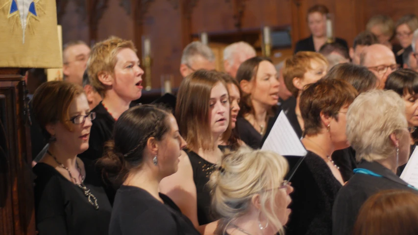 a group of people are gathered together singing