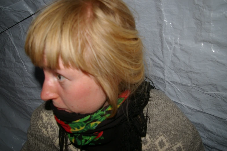 a young blonde girl with a scarf and neck scarf around her neck