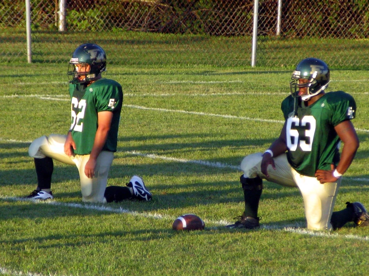 a couple of people that are sitting on a field