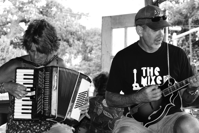 a woman playing a music instrument beside a man