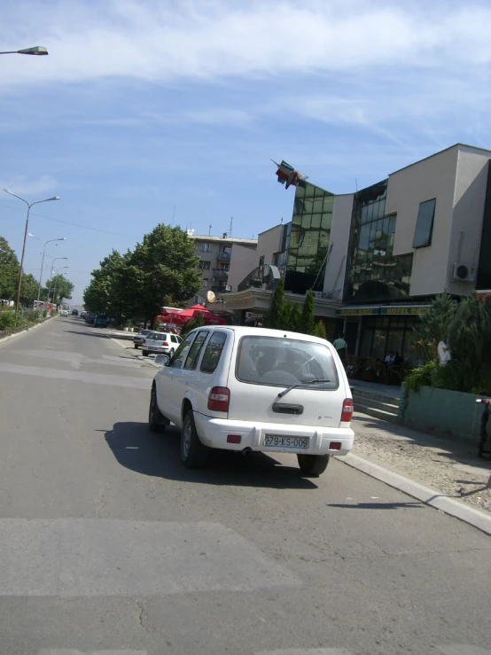 there is a white car that is parked in the street