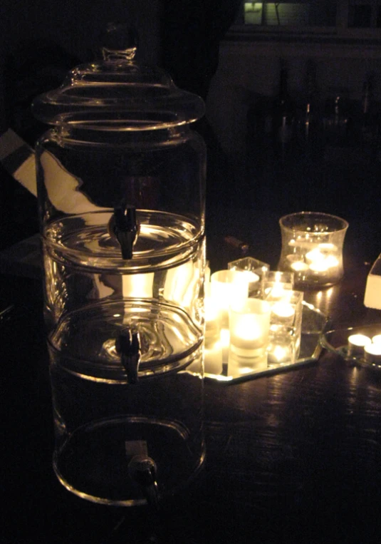 a table is covered with candles in glass containers