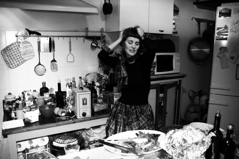 woman in kitchen looking at plates on counter