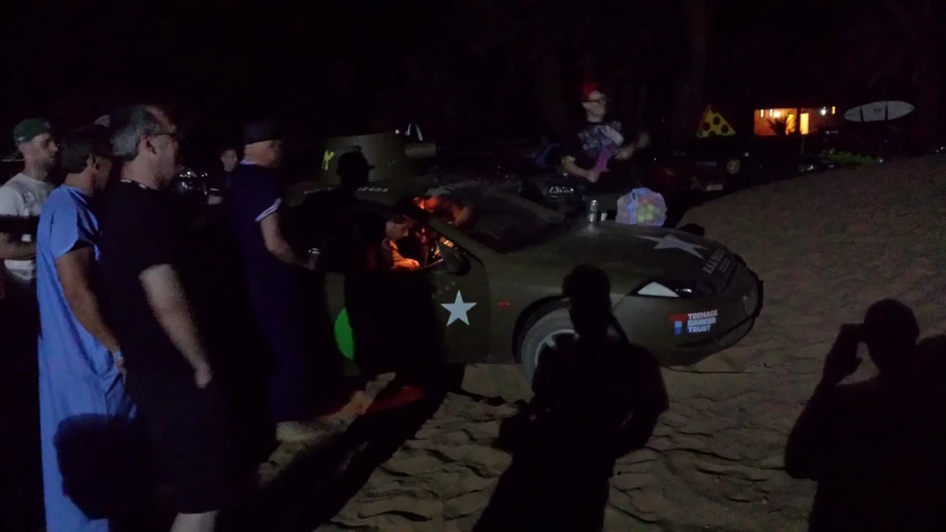 people standing in a line on a sandy area at night