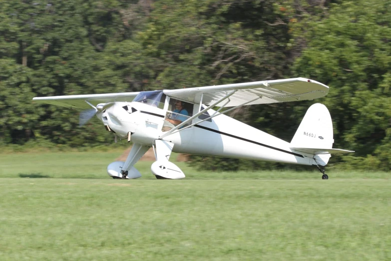 an airplane sitting on top of a lush green field