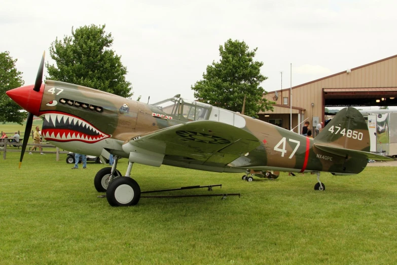 a green and red airplane parked in grass