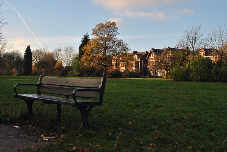 park bench with house in background and green grass