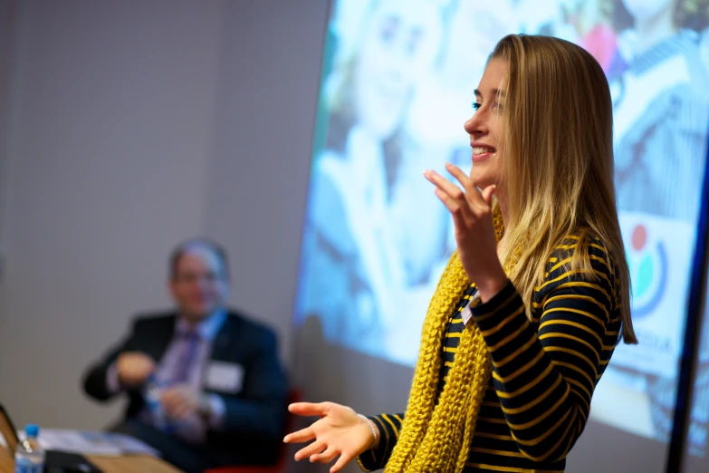 a person giving a lecture in front of two people