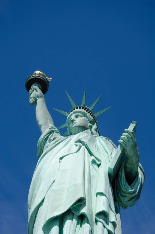 the statue of liberty has a blue sky in the background