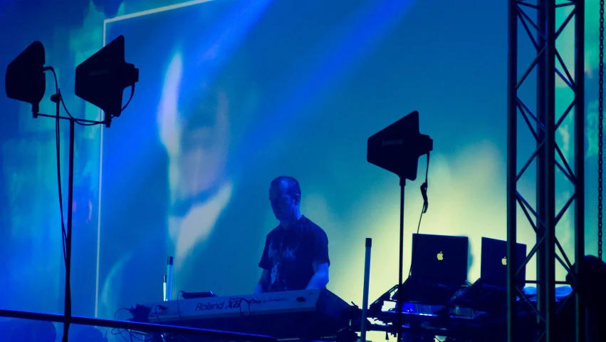 a dj mixing music on a stage during a concert