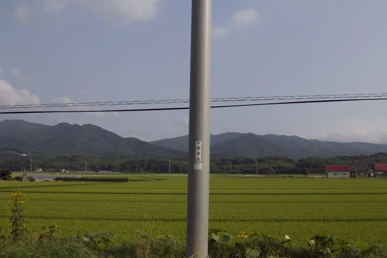 a pole with a street sign and the mountains behind it