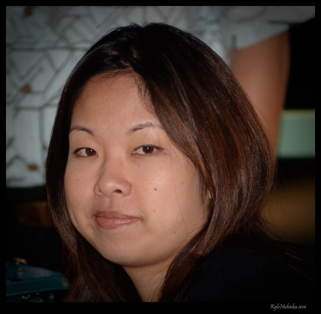 an asian woman smiling and looking directly at the camera