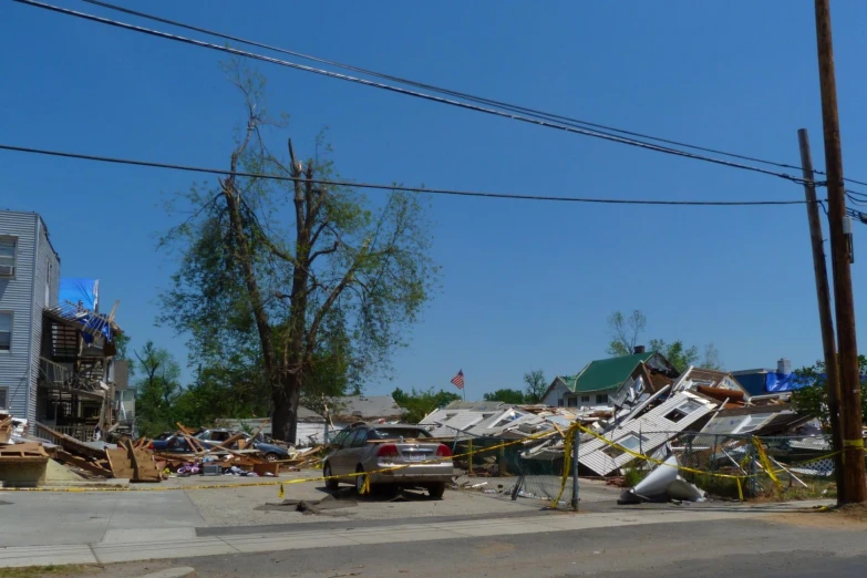 a vehicle parked on the side of a street next to a fallen building