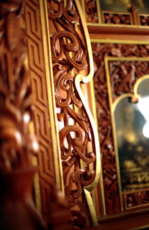 wood carvings adorn the back of this ornate framed mirror