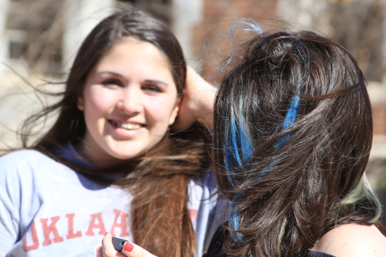 two women hug each other and one woman has her hair wrapped around her shoulders