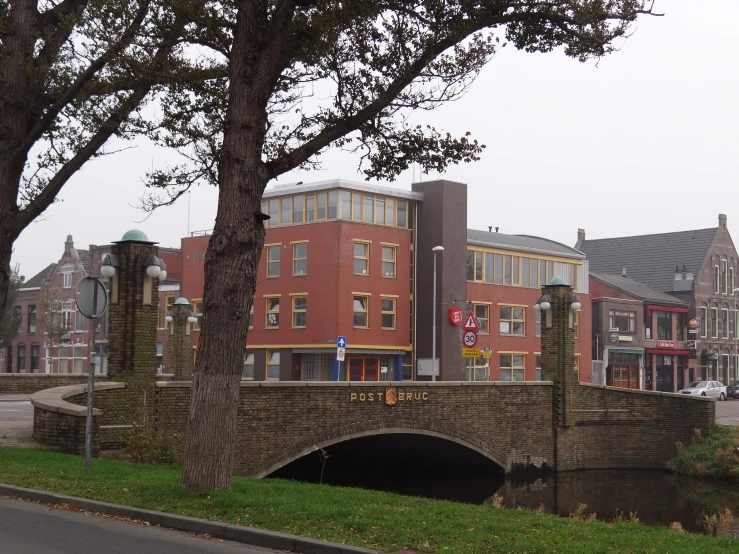 a large brick bridge with a few buildings in the background