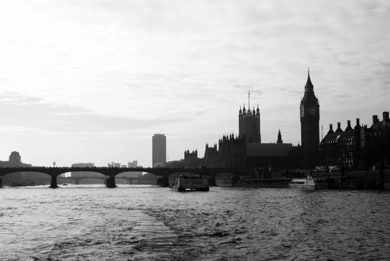 city skyline with a bridge and some boats in the river